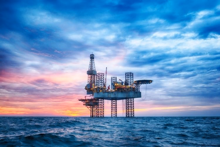 Offshore oil drilling platform in the ocean at sunset representing offshore energy production and oil and gas infrastructure.