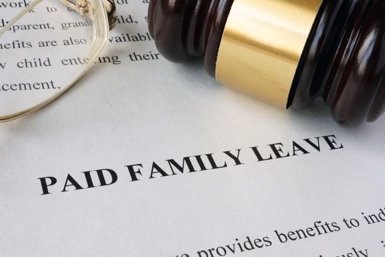 Close-up of a gavel resting near the words “Paid Family Leave,” representing employment law, workplace policies, and employee benefits.